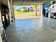 Spacious garage with epoxy floors, showcasing an organized area and view to the outside at 3704 Via Monte Napoleone Dr, Poinciana, FL 34759