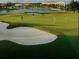 Beautiful aerial view of the golf course and sand trap next to the water and golf players at 3704 Via Monte Napoleone Dr, Poinciana, FL 34759