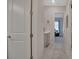 Hallway featuring doors, a vanity, and a glimpse into a bedroom at 3704 Via Monte Napoleone Dr, Poinciana, FL 34759