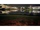 Night view of community buildings reflecting in a pond, enhancing its tranquil beauty at 3704 Via Monte Napoleone Dr, Poinciana, FL 34759