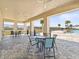 Covered patio area with tables, chairs, and ceiling fans for residents to enjoy overlooking the community pool at 3793 Giorgio Dr, Winter Haven, FL 33884