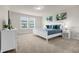 Bright bedroom featuring a white bed with a blue quilt, complemented by leaf-themed wall art at 3974 Lana Ave, Davenport, FL 33897