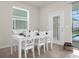 Dining area has a white table set for six beside a glass door leading to the screened pool at 3974 Lana Ave, Davenport, FL 33897