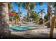 Relaxing hammock garden area with palm trees and comfortable striped hammocks in the sand at 3974 Lana Ave, Davenport, FL 33897