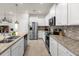 Modern kitchen featuring stainless steel appliances, granite countertops, and white cabinetry at 3974 Lana Ave, Davenport, FL 33897