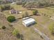 Aerial view of the property showcases the home, barn, and surrounding acreage at 4560 Daugharty Rd, De Leon Springs, FL 32130