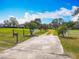 Picturesque driveway lined with white fencing and trees, leading to a stunning home at 4560 Daugharty Rd, De Leon Springs, FL 32130