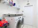 Well-organized laundry room with modern washer and dryer, storage shelves, and neutral walls at 4560 Daugharty Rd, De Leon Springs, FL 32130