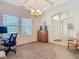 Comfortable living room featuring large windows for natural light, carpet flooring, and traditional chandelier lighting at 4560 Daugharty Rd, De Leon Springs, FL 32130