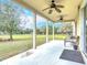 Covered back porch features ceiling fans and overlooks the property's expansive green space at 4560 Daugharty Rd, De Leon Springs, FL 32130