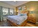 Relaxing main bedroom featuring a wooden bed, accent wall, bedside tables, and natural light at 4967 Windermere Ave, Kissimmee, FL 34746