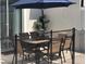 Outdoor dining area with seating for six, shaded by an umbrella, and surrounded by a safety fence at 4967 Windermere Ave, Kissimmee, FL 34746