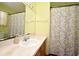 Well-maintained bathroom with a sink, vanity, and shower featuring patterned curtains at 643 Captiva Cir, Kissimmee, FL 34741