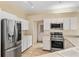 Bright kitchen with stainless steel appliances, white cabinetry, and tile flooring at 736 W Pinewood Ct, Lake Mary, FL 32746