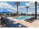 Luxury pool featuring ample lounge chairs and umbrellas for residents to unwind and soak up the sun at 7545 Laureate Blvd # 7202, Orlando, FL 32827