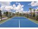 Outdoor tennis court with vibrant blue surface, net, and surrounding greenery for recreational play at 7545 Laureate Blvd # 7202, Orlando, FL 32827