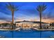 Community clubhouse and pool area at dusk, highlighted by the palm trees in the foreground at 7545 Laureate Blvd # 7203, Orlando, FL 32827