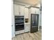 Modern kitchen with stainless steel refrigerator and double oven at 7873 Dausset St, Orlando, FL 32827