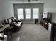 A cozy living room with carpet, a leather couch, and bright windows with shutters at 7873 Dausset St, Orlando, FL 32827