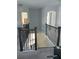 Hallway view to downstairs with black metal staircase and open floor plan to other rooms at 7873 Dausset St, Orlando, FL 32827