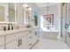 Bright bathroom featuring double sinks, modern fixtures, a soaking tub, and a glass shower enclosure at 831 W Harvard St, Orlando, FL 32804