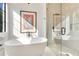 Luxury bathroom with a freestanding soaking tub, glass shower, and a colorful art piece at 831 W Harvard St, Orlando, FL 32804