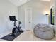 Neutral bedroom with a Peloton bike, beanbag chair, and a window for natural light at 831 W Harvard St, Orlando, FL 32804