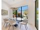 Bright dining area with modern light fixture, glass table and seating, looking out to the serene backyard pool at 831 W Harvard St, Orlando, FL 32804