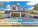 Back exterior view of a two-story home, featuring a pool, patio, and manicured lawn at 831 W Harvard St, Orlando, FL 32804