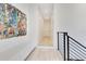 Bright hallway featuring modern railing, white walls, built-in bench and colorful abstract painting at 831 W Harvard St, Orlando, FL 32804