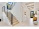 Hallway with modern staircase, wood accents, and natural light from the front door at 831 W Harvard St, Orlando, FL 32804