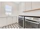 Bright modern laundry room featuring black and white tiled floors and new washer and dryer at 831 W Harvard St, Orlando, FL 32804