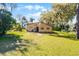 A large backyard featuring a well maintained lawn, mature shade trees, and outdoor seating at 866 Gatlin Ave, Orlando, FL 32806