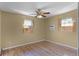 A bedroom with wood-look flooring, two windows, and a ceiling fan at 866 Gatlin Ave, Orlando, FL 32806