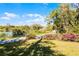 Scenic street view with lush greenery, blooming azaleas, and a glimpse of a tranquil lake under a clear blue sky at 866 Gatlin Ave, Orlando, FL 32806