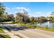 Picturesque street view showcasing mature trees draped with Spanish moss along a serene lake, reflecting clear blue skies at 866 Gatlin Ave, Orlando, FL 32806