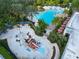 Aerial view of splash pad and resort-style pool with lounge seating and umbrellas at 929 Conch Rd, Davenport, FL 33896