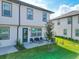 Townhome backyard with a patio, green lawn, and a newly planted shade tree at 929 Conch Rd, Davenport, FL 33896