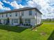 Townhome backyard featuring a patio, green lawn, and view of neighboring properties at 929 Conch Rd, Davenport, FL 33896