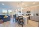 Open-concept kitchen with gray cabinets, stainless steel appliances, and bar seating overlooking living room at 929 Conch Rd, Davenport, FL 33896