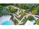 Aerial view of an intricate mini-golf course winding through a lush landscape next to a pool at 929 Conch Rd, Davenport, FL 33896