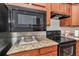 Close-up of kitchen featuring granite countertops, a microwave, and stainless steel oven at 9472 Sw 76Th St, Ocala, FL 34481