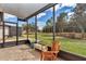 Relaxing screened lanai with brick-paved floors and views of the lush green backyard at 9472 Sw 76Th St, Ocala, FL 34481