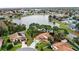 Lakeside home aerial view shows its proximity to community, mature landscaping and water views at 100 Honeywood Ct, Kissimmee, FL 34743