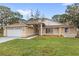 Inviting single-story home with manicured lawn, neutral paint, white trim, and an attached two-car garage at 100 Honeywood Ct, Kissimmee, FL 34743