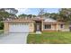 Inviting single-story home with manicured lawn, neutral paint, white trim, and an attached two-car garage at 100 Honeywood Ct, Kissimmee, FL 34743