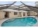 Large screened-in pool with hot tub and access to home through sliding glass doors at 100 Honeywood Ct, Kissimmee, FL 34743