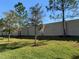 This backyard view highlights newly planted trees, well maintained lawn and a privacy fence at 1013 Flowing Tide Dr, Orlando, FL 32828