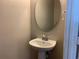 Bathroom featuring a white pedestal sink and oval mirror at 1013 Flowing Tide Dr, Orlando, FL 32828