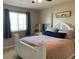 Comfortable bedroom with a white bed frame, neutral-colored walls, and a window with curtains at 1013 Flowing Tide Dr, Orlando, FL 32828